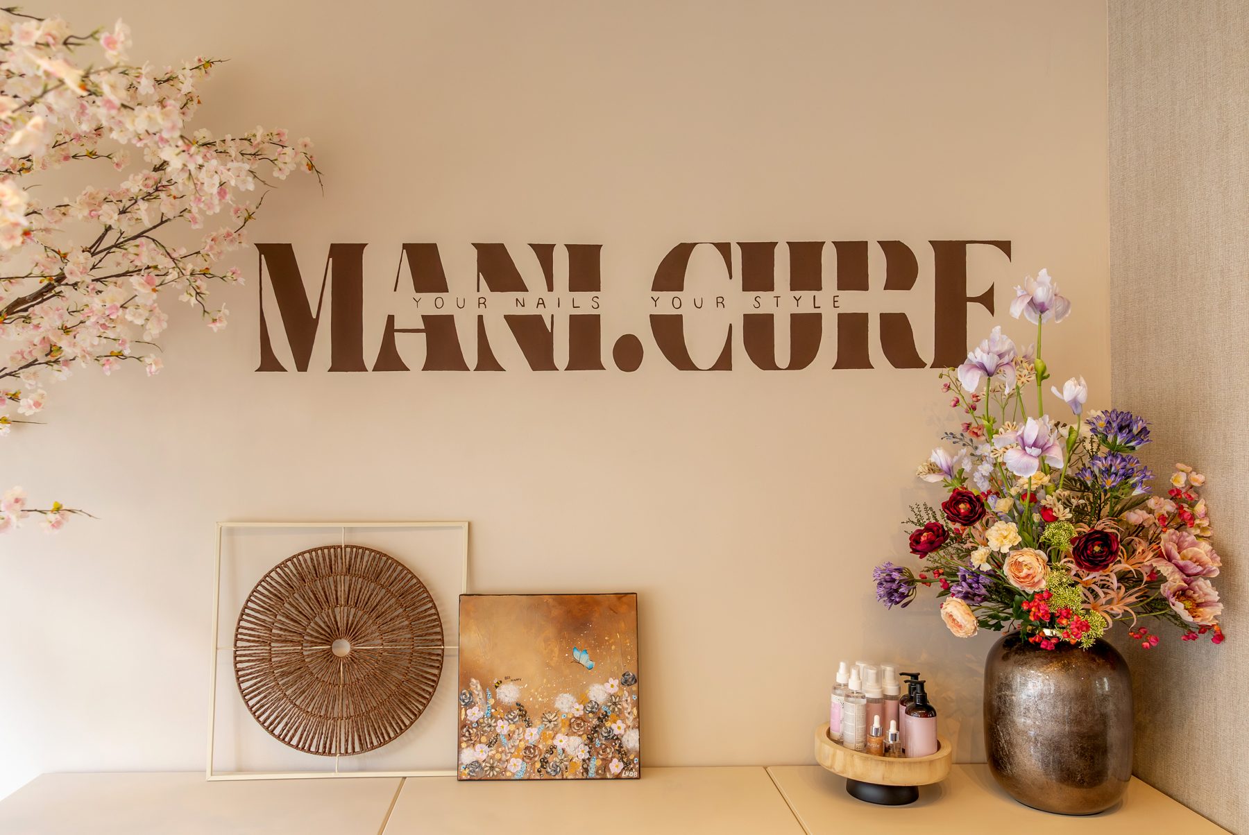 De wand met het logo van Mani.Cure in de salon